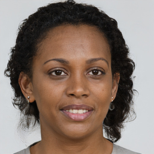 Joyful black young-adult female with medium  brown hair and brown eyes