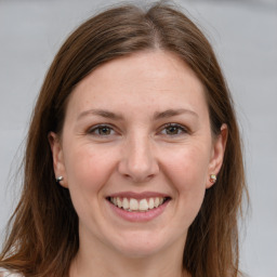 Joyful white young-adult female with long  brown hair and grey eyes