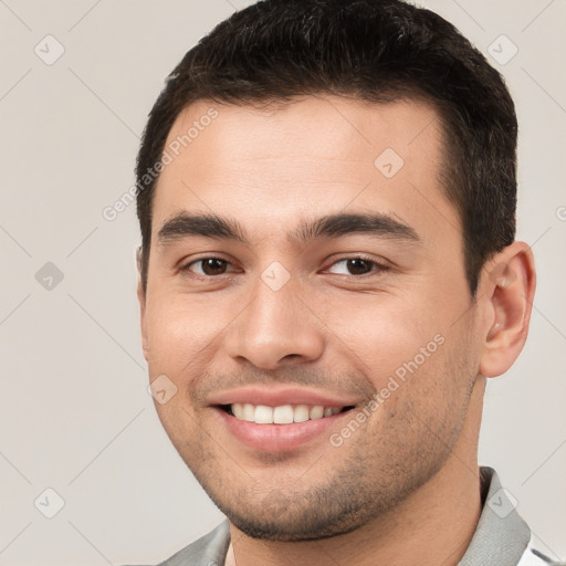 Joyful white young-adult male with short  brown hair and brown eyes