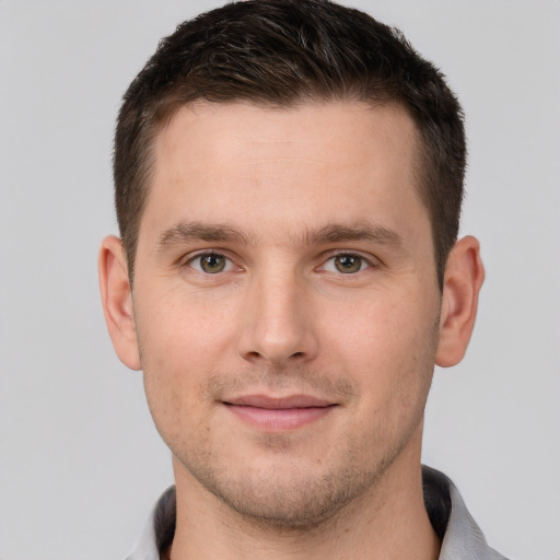 Joyful white young-adult male with short  brown hair and grey eyes