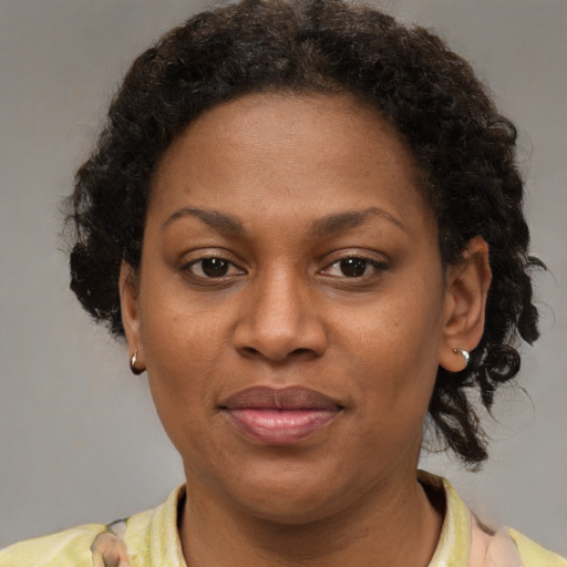 Joyful black adult female with short  brown hair and brown eyes