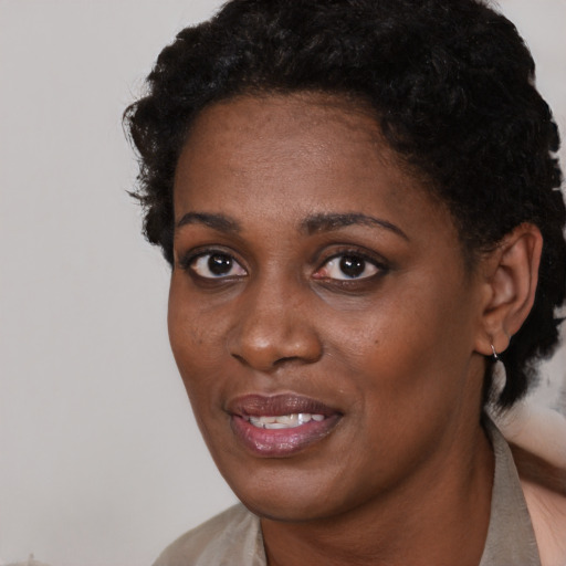 Joyful black young-adult female with short  black hair and brown eyes
