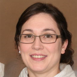 Joyful white adult female with medium  brown hair and blue eyes