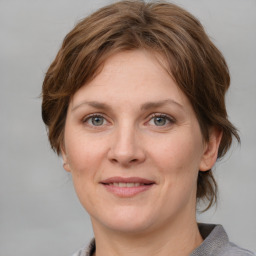 Joyful white young-adult female with medium  brown hair and blue eyes