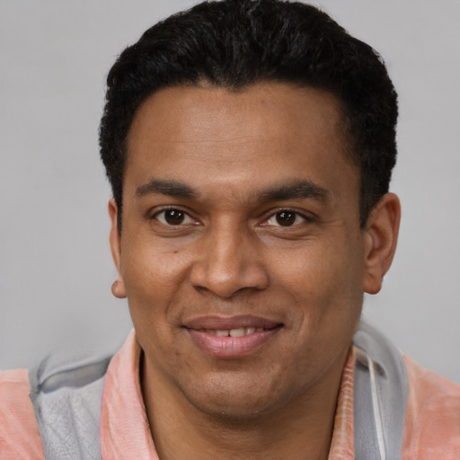 Joyful latino young-adult male with short  black hair and brown eyes