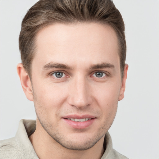 Joyful white young-adult male with short  brown hair and grey eyes