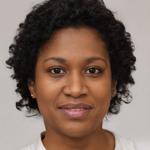 Joyful black young-adult female with short  brown hair and brown eyes