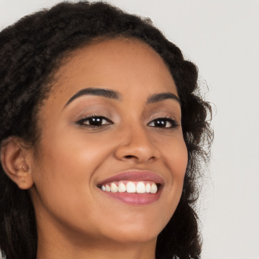 Joyful latino young-adult female with long  brown hair and brown eyes