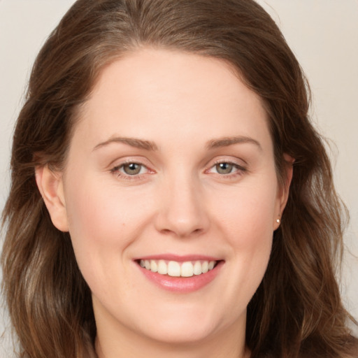 Joyful white young-adult female with long  brown hair and grey eyes