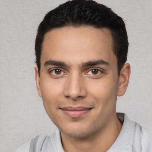 Joyful white young-adult male with short  black hair and brown eyes