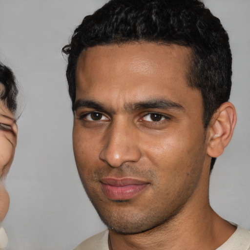 Joyful white young-adult male with short  black hair and brown eyes