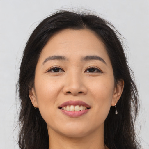 Joyful asian young-adult female with long  brown hair and brown eyes