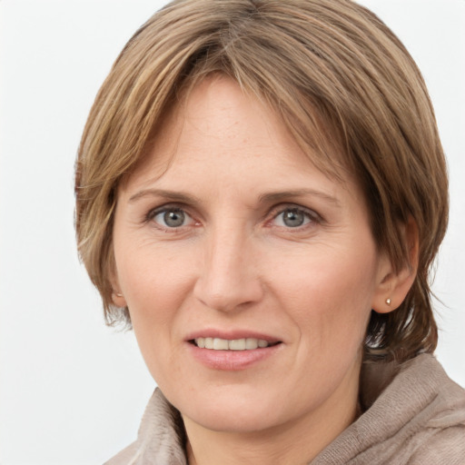 Joyful white adult female with medium  brown hair and grey eyes