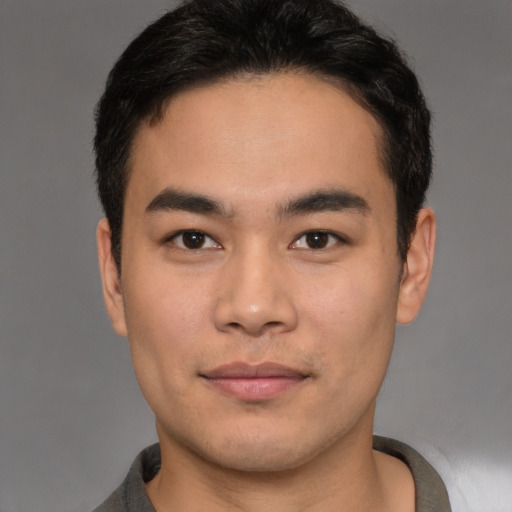Joyful asian young-adult male with short  brown hair and brown eyes