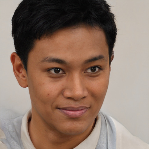 Joyful latino young-adult male with short  brown hair and brown eyes