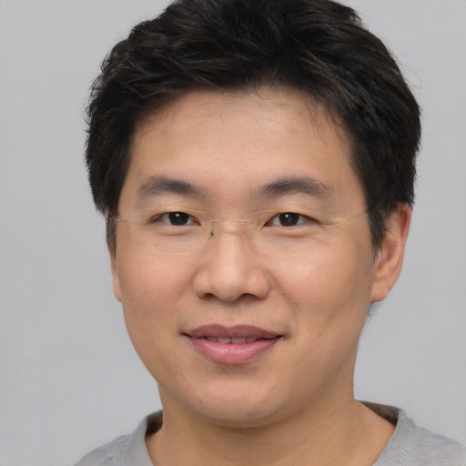 Joyful asian young-adult male with short  brown hair and brown eyes