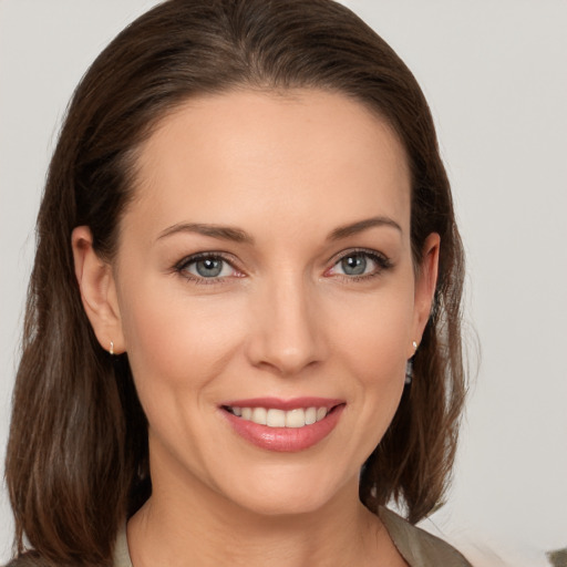 Joyful white young-adult female with medium  brown hair and grey eyes