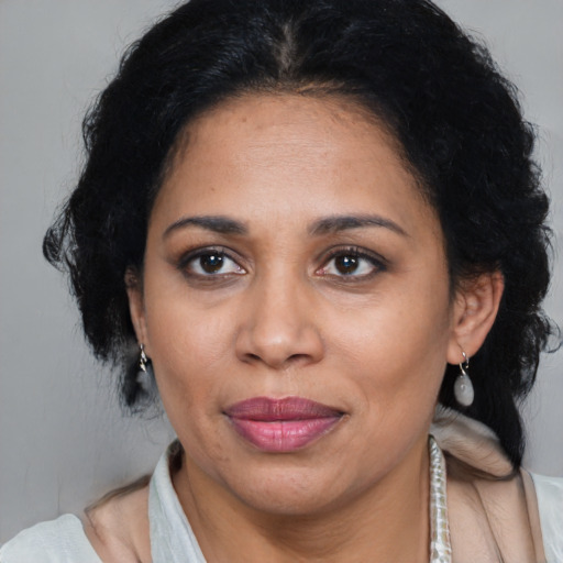 Joyful latino adult female with medium  brown hair and brown eyes