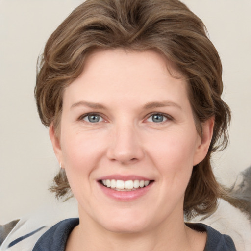 Joyful white young-adult female with medium  brown hair and blue eyes