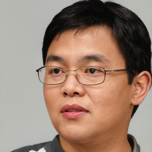 Joyful asian adult male with short  brown hair and brown eyes