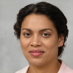 Joyful latino adult female with medium  brown hair and brown eyes