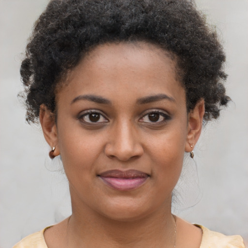 Joyful black young-adult female with short  brown hair and brown eyes