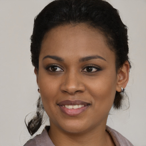 Joyful black young-adult female with short  brown hair and brown eyes