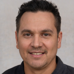 Joyful white adult male with short  brown hair and brown eyes