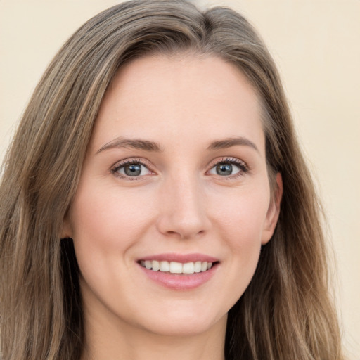 Joyful white young-adult female with long  brown hair and green eyes