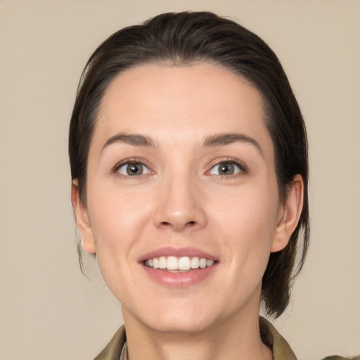 Joyful white young-adult female with medium  brown hair and grey eyes