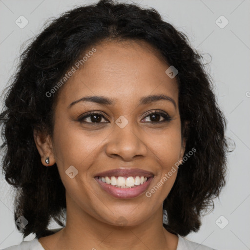 Joyful black young-adult female with long  brown hair and brown eyes