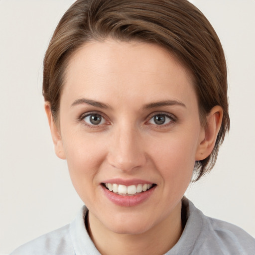 Joyful white young-adult female with short  brown hair and grey eyes