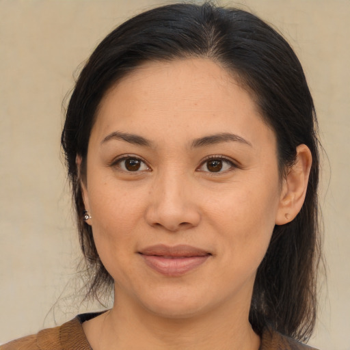 Joyful asian adult female with medium  brown hair and brown eyes