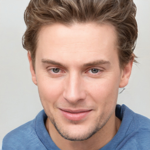 Joyful white young-adult male with short  brown hair and blue eyes