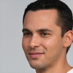 Joyful white young-adult male with short  black hair and brown eyes