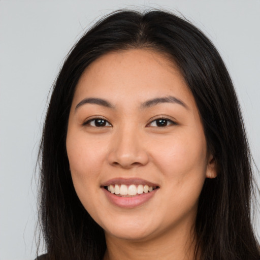 Joyful latino young-adult female with long  brown hair and brown eyes