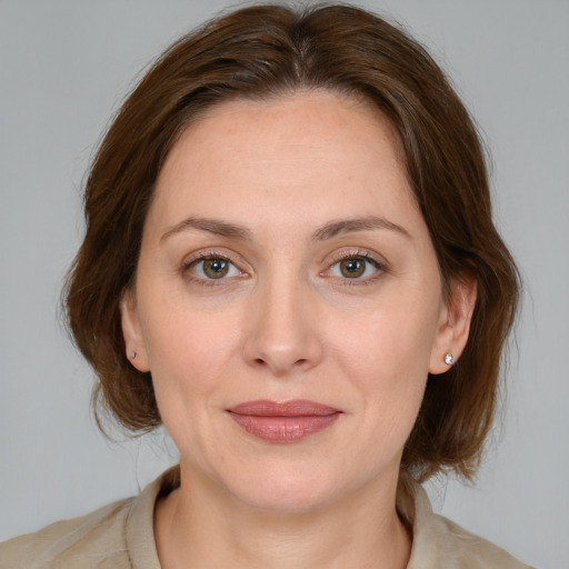 Joyful white young-adult female with medium  brown hair and blue eyes