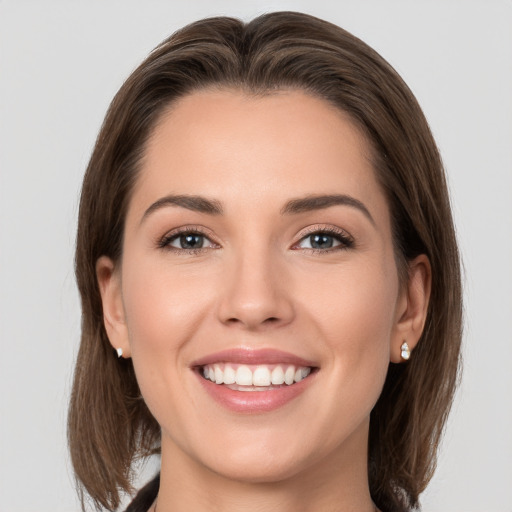 Joyful white young-adult female with medium  brown hair and grey eyes