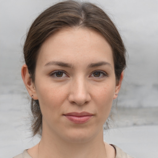 Joyful white young-adult female with medium  brown hair and grey eyes