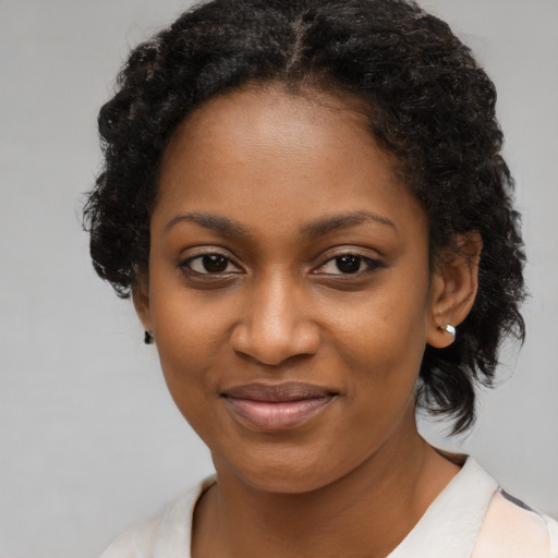 Joyful black young-adult female with medium  brown hair and brown eyes