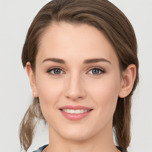 Joyful white young-adult female with medium  brown hair and grey eyes