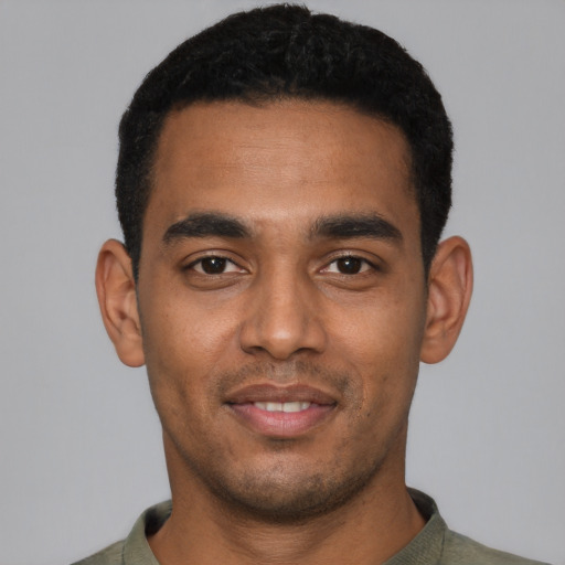 Joyful black young-adult male with short  black hair and brown eyes