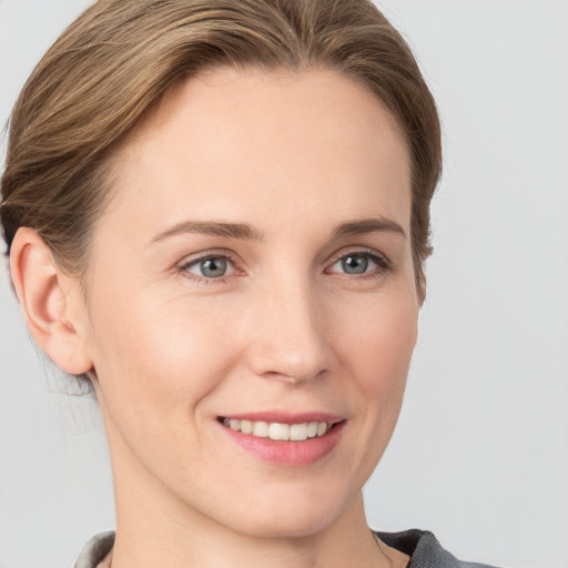 Joyful white young-adult female with medium  brown hair and grey eyes