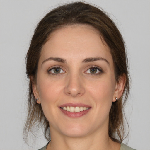 Joyful white young-adult female with medium  brown hair and green eyes