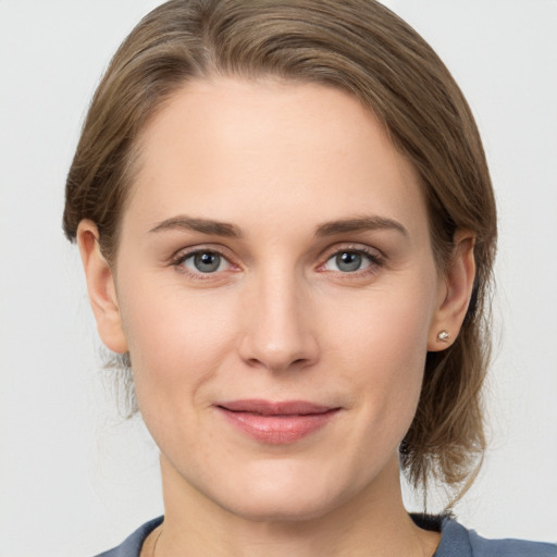 Joyful white young-adult female with medium  brown hair and grey eyes