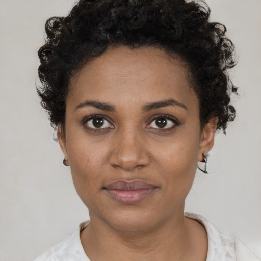 Joyful black young-adult female with short  black hair and brown eyes
