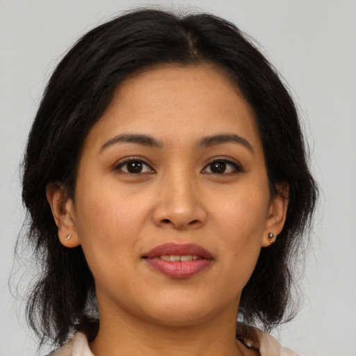 Joyful latino young-adult female with medium  brown hair and brown eyes