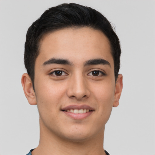 Joyful latino young-adult male with short  brown hair and brown eyes