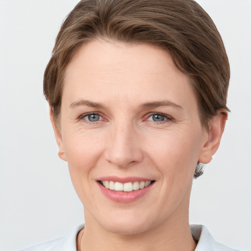 Joyful white young-adult female with short  brown hair and grey eyes