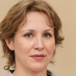 Joyful white adult female with medium  brown hair and green eyes